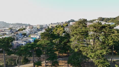 overhead drone footage captures the texture and rhythm of residential life across excelsior and portola neighborhoods under soft california daylight. ascending drone shot.