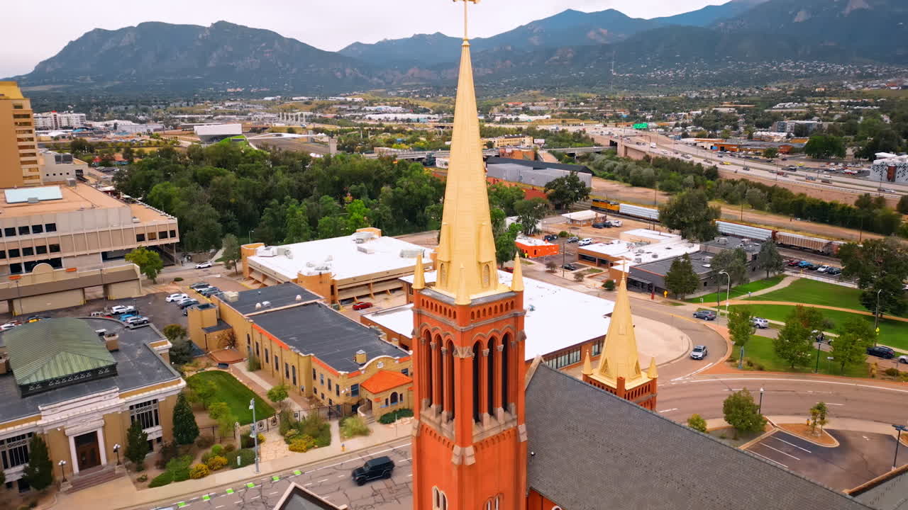 St. Mary's Cathedral, Colorado Springs, Colorado, USA steeple from drone footage. Scenery of the city surrounded by the mountains at backdrop