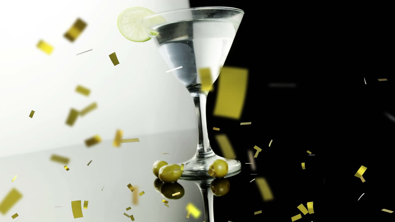 황금 콘페티가 검은 배경에 라임  ⁇ 으로  ⁇ 테일 유리 위에 떨어집니다.