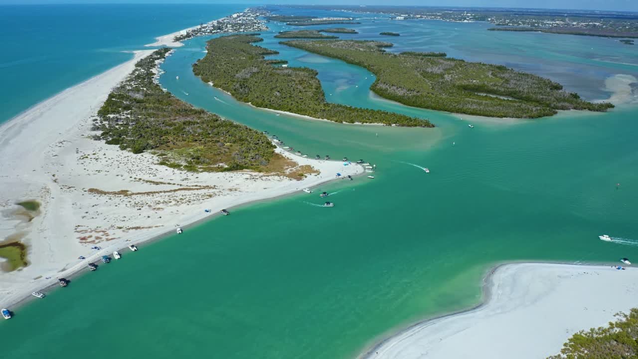 Acque turchesi circondano coste sabbiose e isole di mangrovie in Florida, dove le barche sono ancorate e navigano attraverso l'insenatura in una giornata calma e soleggiata