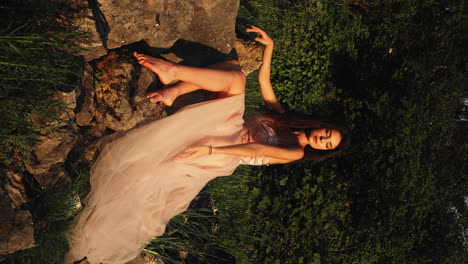 Beautiful-woman-sitting-on-rocks-posing-confidently-in-her-pink-wedding-dress