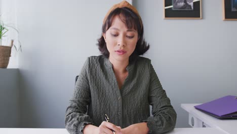 Portrait-of-biracial-businesswoman-having-video-call-and-looking-at-camera-at-office