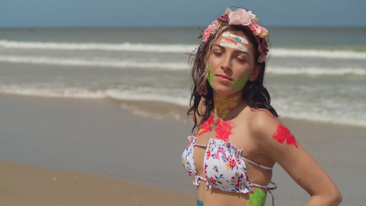 на солнечных пляжах карибского бассейна молодая девушка в бикини добавила цвет своей художественной краской на тело.