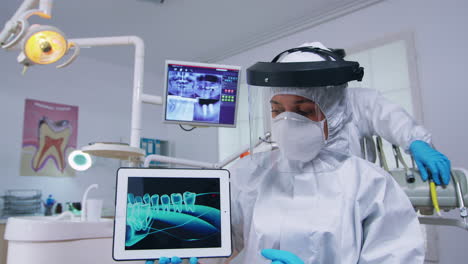 médico mostrando rayos x digitales en la tableta en el consultorio dental con nuevo normal