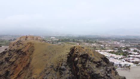 Grupo-De-Amigos-Disfrutando-De-La-Vista-Del-Paisaje-Urbano-Desde-Un-Acantilado-De-Gran-Altura,-Perú