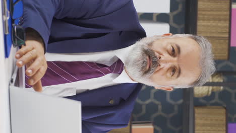 vídeo vertical de un viejo hombre de negocios asintiendo negativo y negativo a la cámara.
