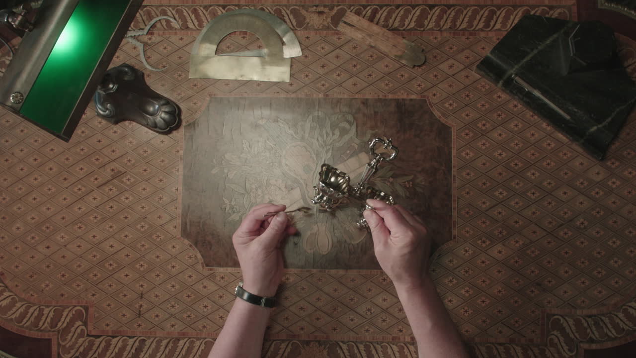 An older man evaluates an old silver item