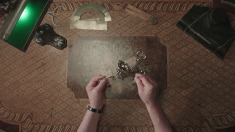 an older man evaluates an old silver item