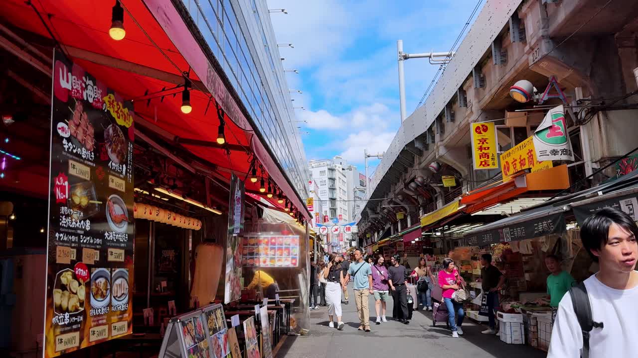 Bustling Japanese street market with shops, people, and bright blue sky overhead