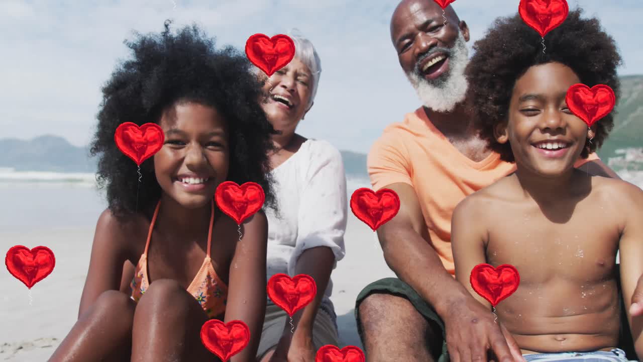 Animazione di icone a forma di cuore su famiglia afroamericana felice in spiaggia