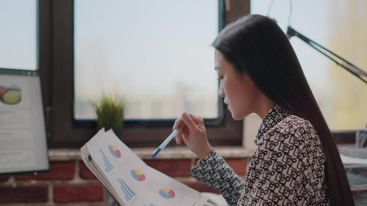 Close up of woman comparing charts on papers and computer