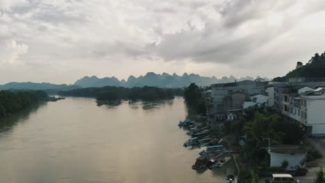 flooded river on overcast day in china, karst mountains in background