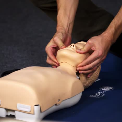 practical course on a dummy's head. medic showing medical exercise on a mannequin in the training center. close-up