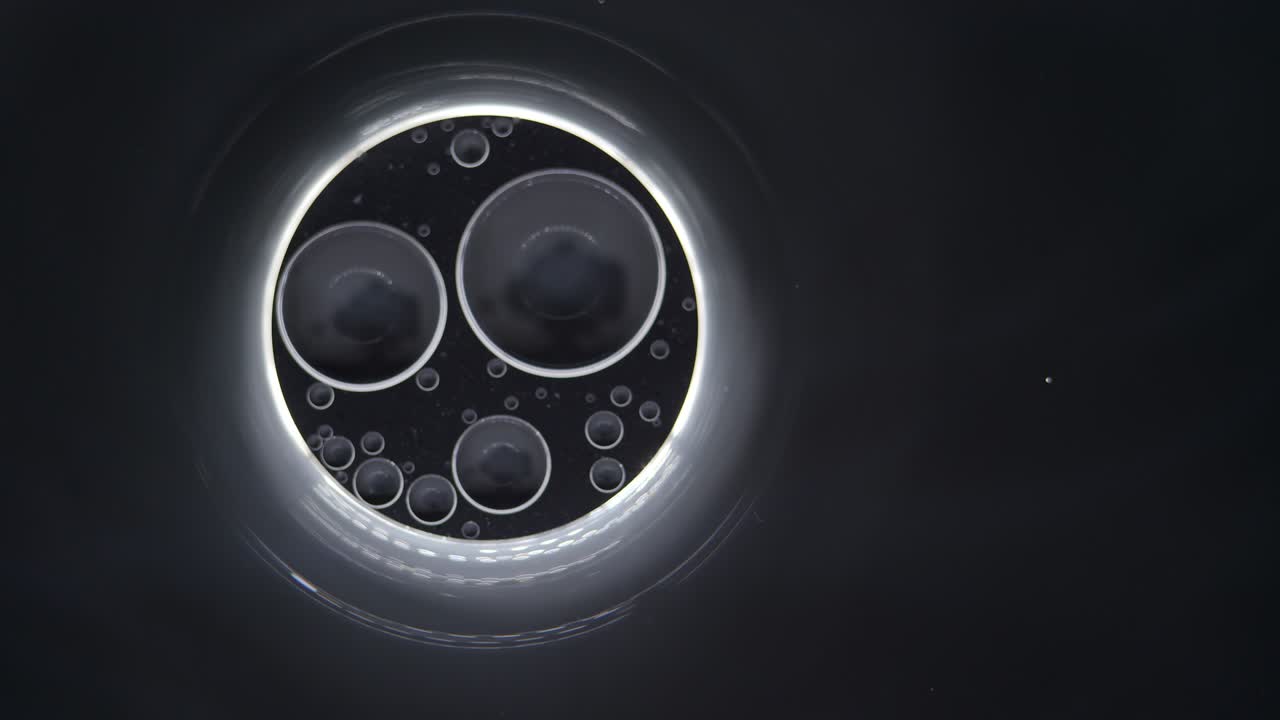 검은 바탕에 있는 거품 속의 추상적인 투명한 거품, 예술적인 검은색과 색 페인트 바탕, 다채로운 거품.