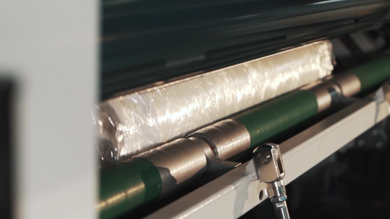 대규모 생산에서 스트레치 필름으로 제품을 포장하는 포장 기계의 클로즈업