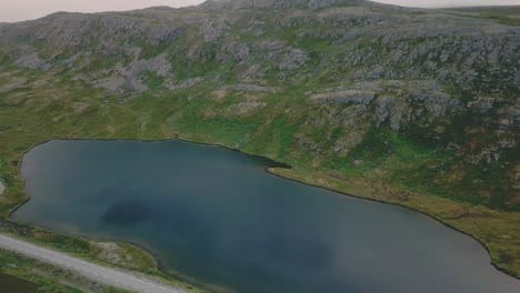 Movimiento-Lateral-De-Un-Dron-Disparado-Junto-A-Un-Lago-Y-Una-Colina-En-Una-Mañana-Nublada