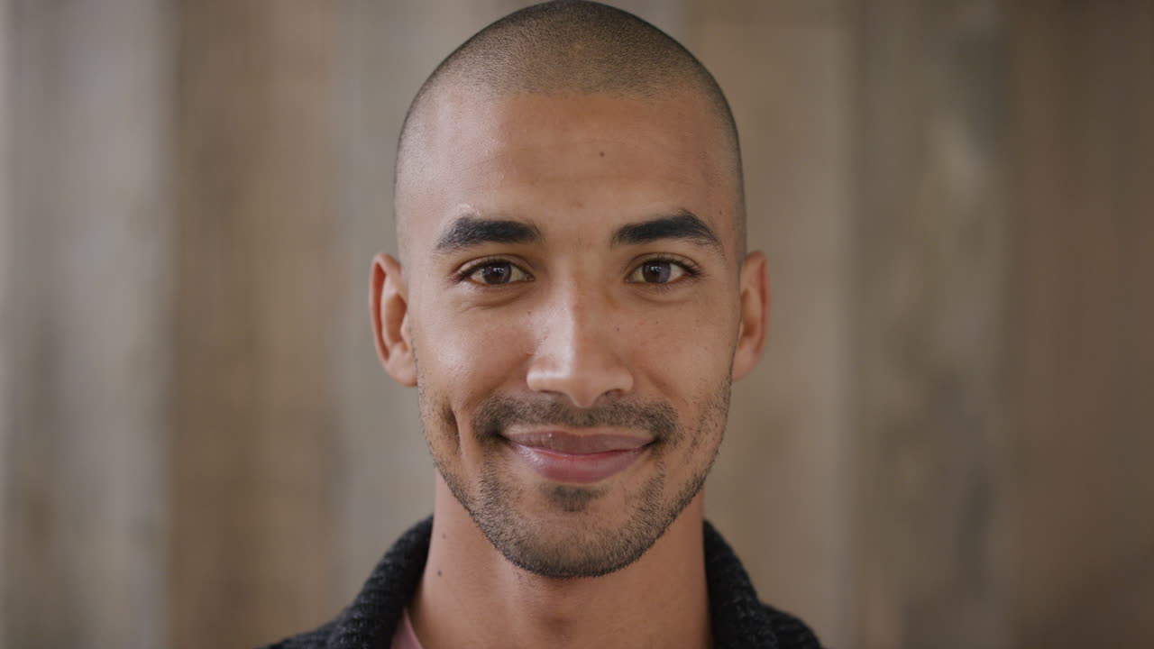 retrato en primer plano de un joven atractivo de raza mixta sonriendo disfrutando de un estilo de vida feliz mirando a la cámara fondo de madera cámara lenta