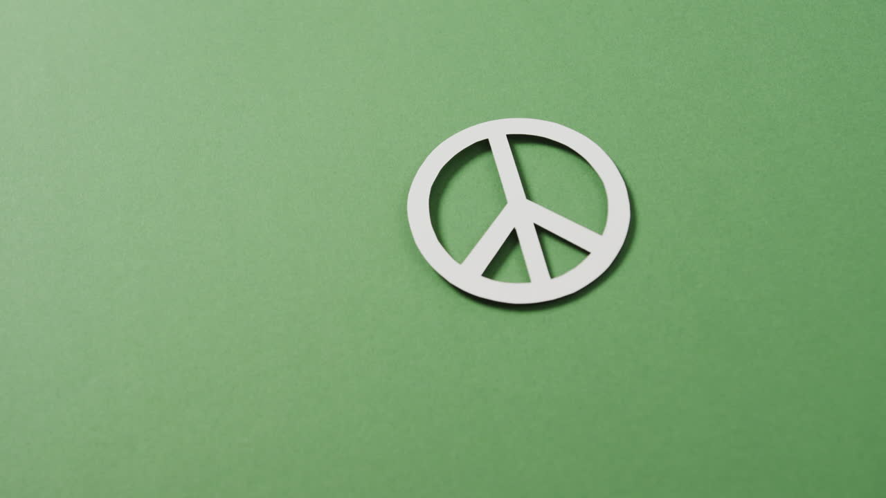 녹색 배경 에 있는  ⁇ 색 평화 표지판 과 복사 공간 의 클로즈업