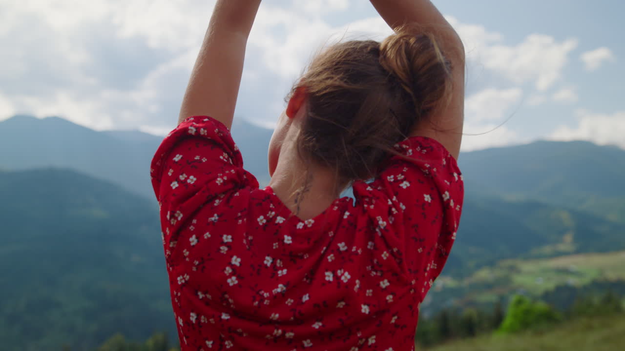 mujer relajándose levantando las manos al cielo nublado en primer plano. vista de atrás chica disfrutando del descanso