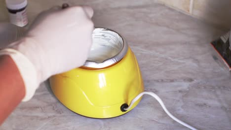 mujer caucásica usando un crisol de dulces eléctrico