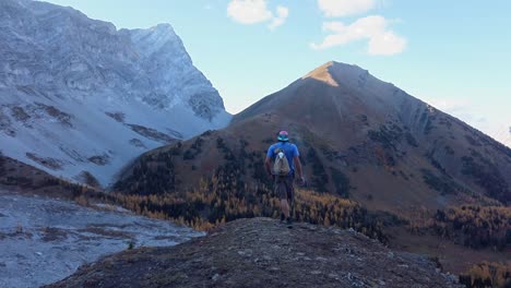 Hiker-smoking-larch-yellow-forest-in-mountains-followed-Kananaskis-Alberta-Canada