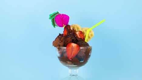 delicioso helado de chocolate con fresas y decoraciones sobre fondo azul