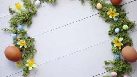 guirnalda decorativa colorida de los huevos de pascua en el fondo de la tabla de madera blanca