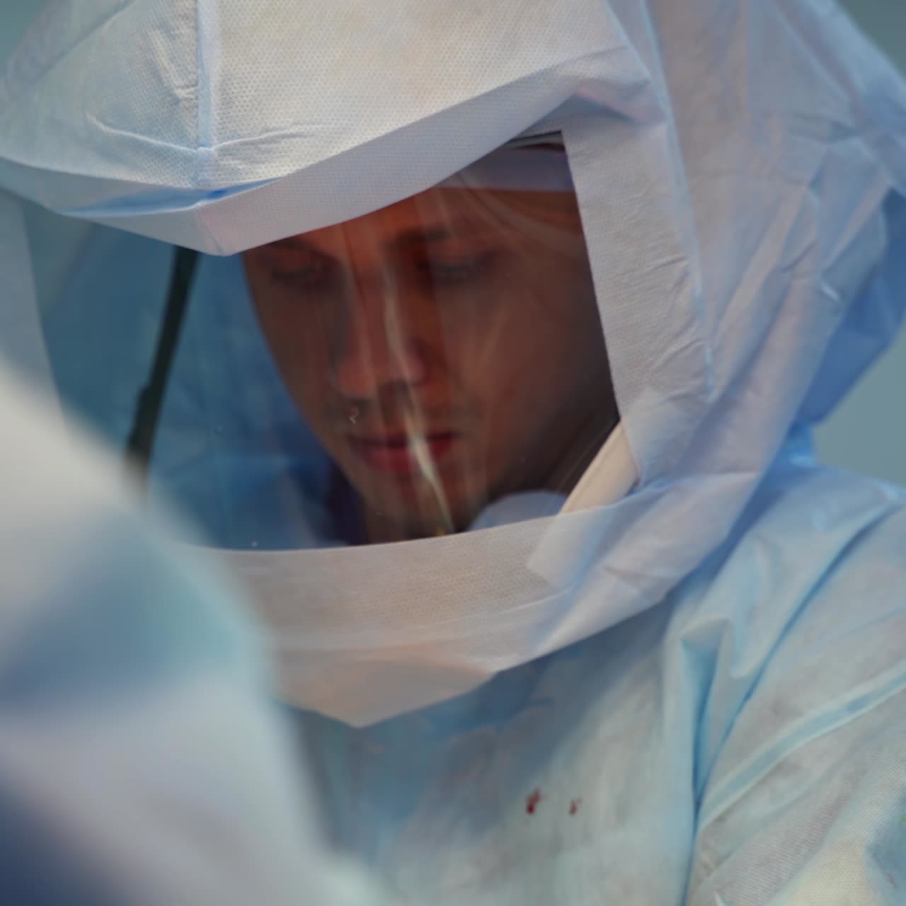 Doctor in protective suit. Face of a surgeon in special medical uniform conducting an operation in the hospital. Healthcare concept.