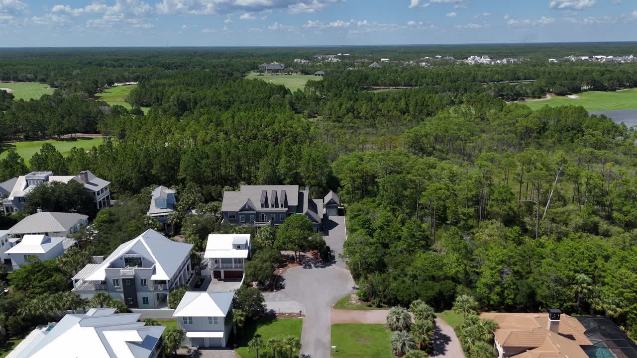 White seaside and luxury town homes among dense green forest on a wide and row layout, 30A, Florida, USA