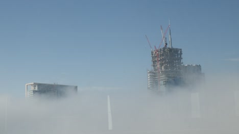 tres rascacielos sobre las nubes, uno está en construcción