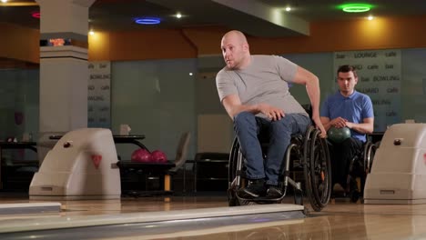 dos jóvenes discapacitados en sillas de ruedas jugando al bolos en el club