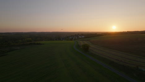 beautiful golden hour scene with small village and green fields below