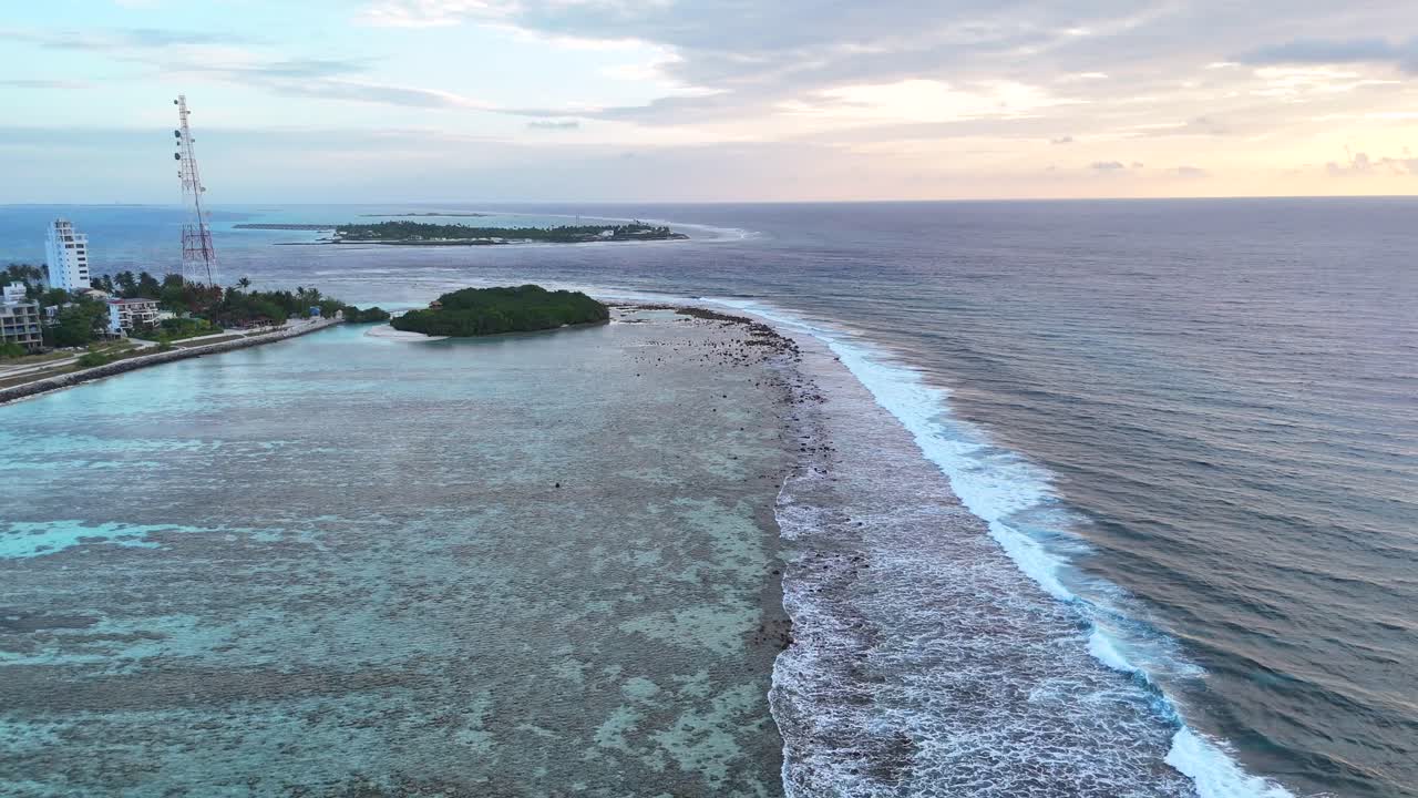 Drone aereo, Thulusdhoo Maldive, isola tropicale esotica remota, barriera corallina, sabbia bianca, acqua turchese, Atollo di Kaafu, onde da surf