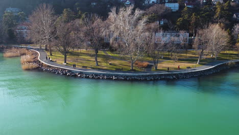 kis mohle pier along vivid green lake waters surrounded by trees and residential shoreline