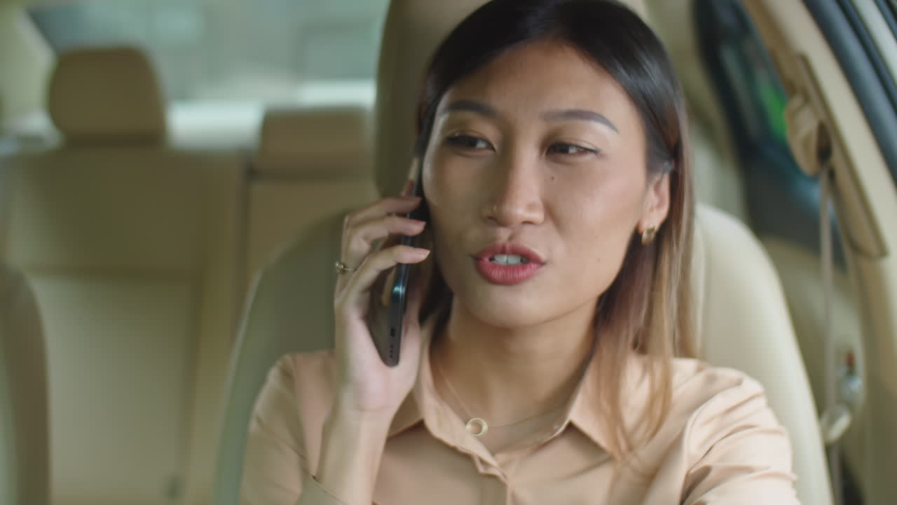 Asian Business Lady Talking on Phone in Car