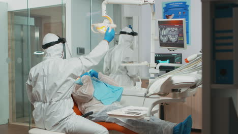 doctor in protective suit using sterilized dentl tools