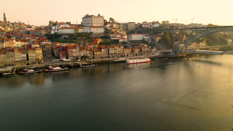 colpo di drone discendente del fiume douro e paesaggio urbano storico di porto durante l'ora del tramonto