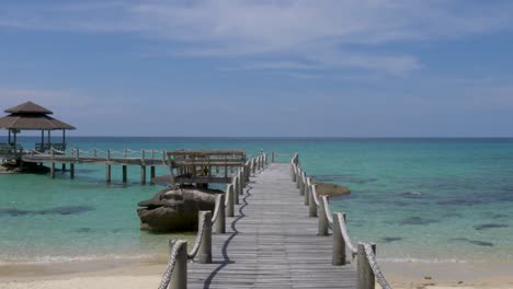 POV-Walking-on-wooden-footbridge-that-leads-to-the-sea