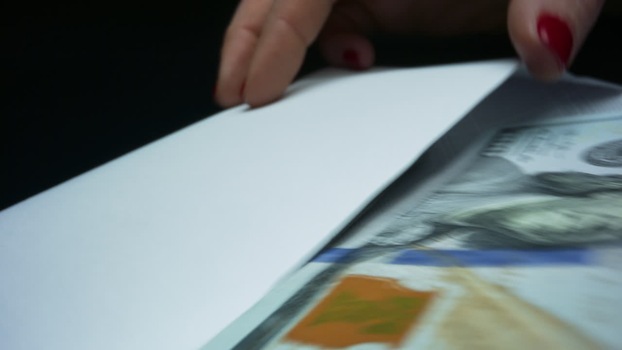 Business woman holding envelope with US money banknotes of new 100 dollars