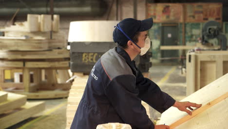 worker measuring wood in a woodworking factory