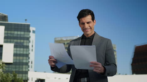 Empresario-Leyendo-Documentos-En-La-Calle.-Trabajador-Mirando-Diagramas-Al-Aire-Libre