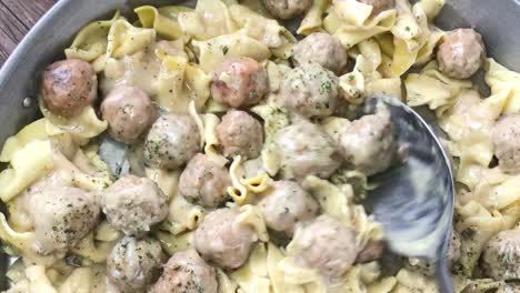 stirring large pan of swedish meatballs top view