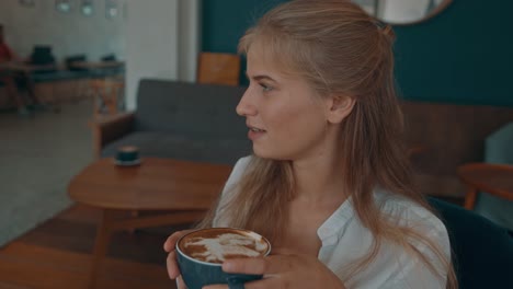 woman enjoying a latte art coffee in a cozy cafe