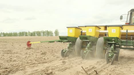 tractor con plantadoras de precisión especiales, el sembrador está trabajando en el campo, la maquinaria agrícola está plantando maíz o semillas de girasol en tierras recién aradas.