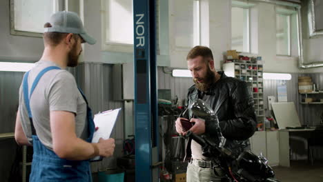 Two-men-talking-at-the-garage