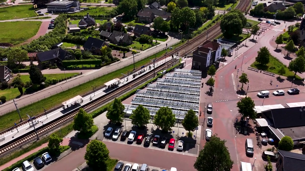 Luchtfoto van een trein die aankomt op een klein stationsgebouw