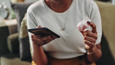 person using smartphone and holding pills