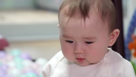 그녀의 놀이터 안에서 놀고 있는 통통한 뺨을 가진 행복한 아기 소녀