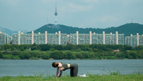 Mujer-Deportiva-Hace-Ejercicio-Haciendo-Yoga-En-El-Parque-Del-Río-Han-En-Seúl