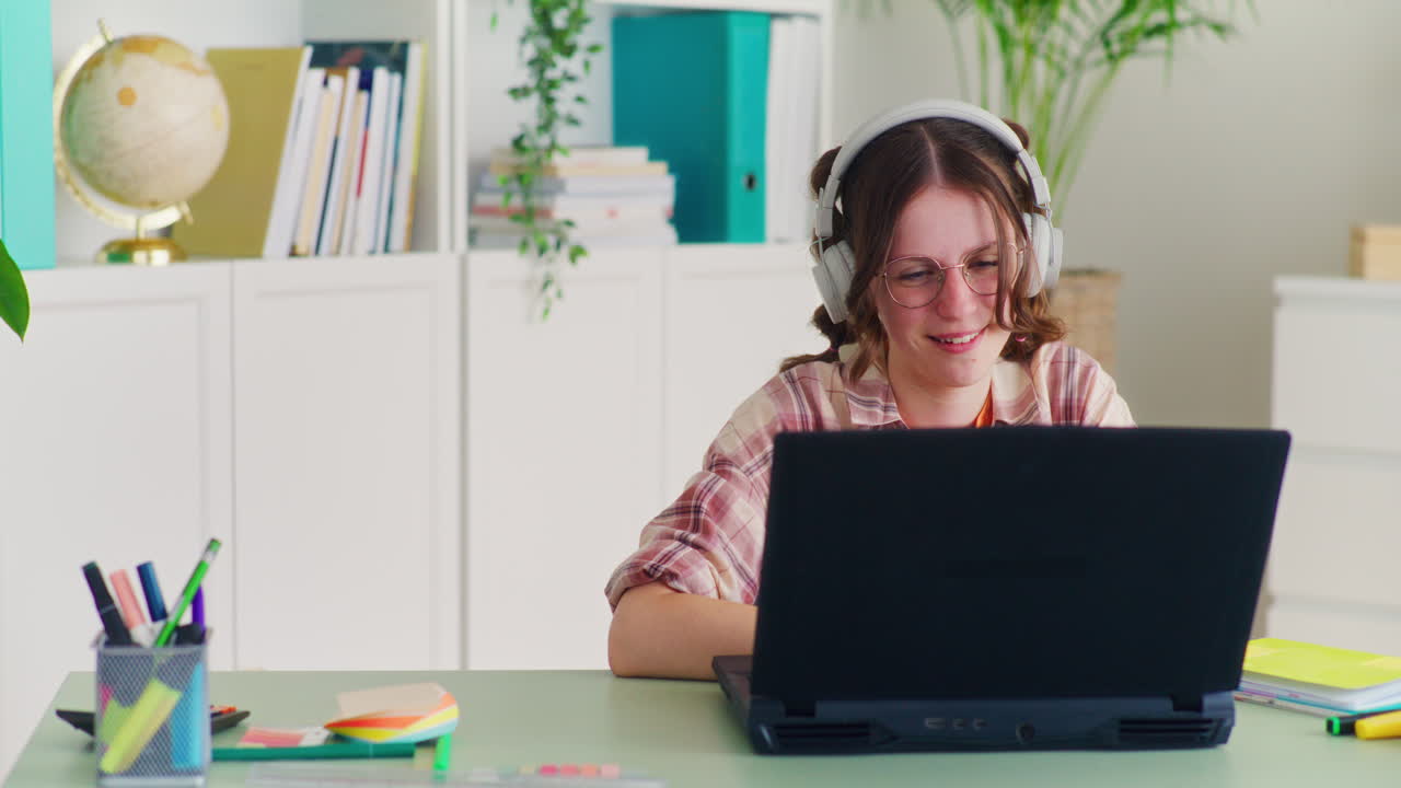 Happy Student Studies Remotely on the Computer and Listens to Music